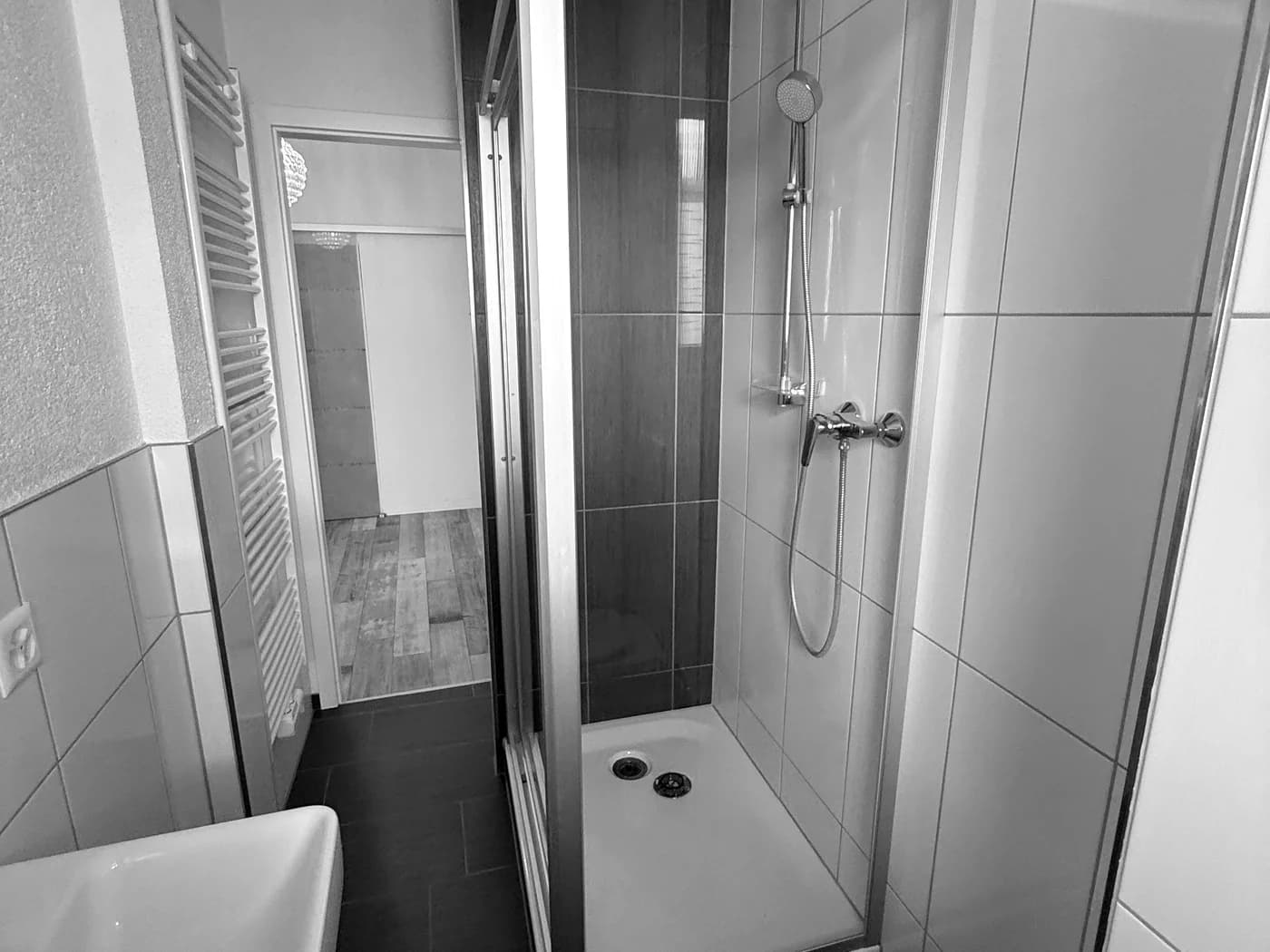 Neu gefliestes Bad mit bodengleicher Duschkabine und Handtuchheizkörper